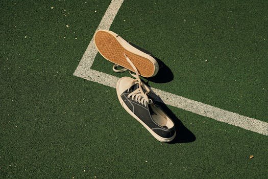 Lone sneakers on a green sports field, symbolizing stillness and solitude. best padel shoes