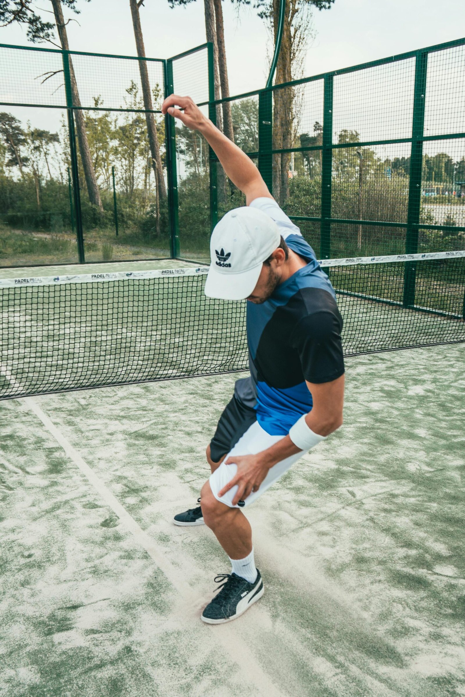 Man in sportswear energetically celebrating on a tennis court for the padel tennis court size post