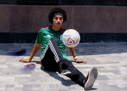 Man with afro performing soccer tricks outdoors. Sports and lifestyle scene. Freestyle Football Ball page