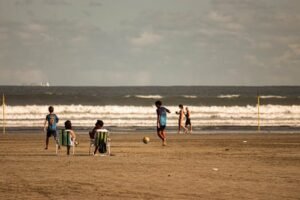 Casual beach soccer game with friends on a sunny day at the shore.for action sports equipment page
