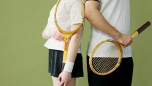 Close-up of tennis players holding vintage wooden rackets against a green backdrop. for padel clothing page